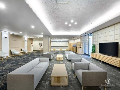a waiting room with couches and a flat screen tv at Daiwa Roynet Hotel Morioka in Morioka