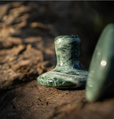 a green vase sitting on top of a rock at The Goose lodge in Calveley
