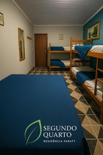 a room with two bunk beds and a blue rug at Casa Luke Paraty in Paraty