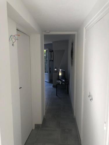 un couloir aux murs blancs et un couloir avec une porte dans l'établissement RDJ dans villa Antibes, à Antibes