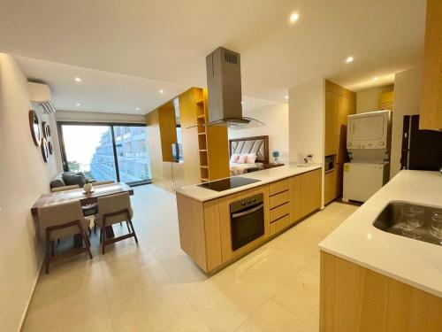 a large kitchen with a sink and a table with a dining room at Aria Ocean Condominios in Nuevo Vallarta 