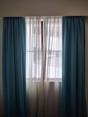 a window with blue and white curtains at Alamis City Kuala Lumpur - Formerly EDC Hotel Kuala Lumpur in Kuala Lumpur