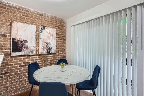 a dining room with a white table and blue chairs at Your Stylish King Suite Getaway - Sleeps 4 - Pool, Prkg in Austin