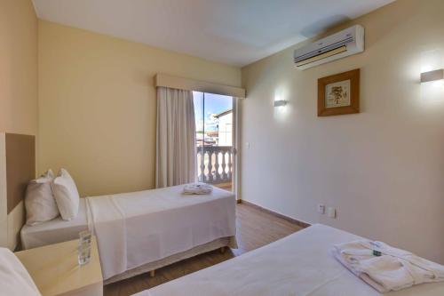 a hotel room with two beds and a balcony at Thermas de Olimpia Resort in Olímpia