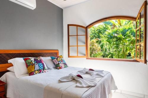 une chambre avec un lit et une fenêtre dans l'établissement Recanto da Margo 1, casa com acesso a cachoeira, à Parati