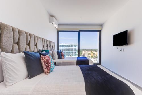 a bedroom with a large bed with a large window at Aria Ocean Condominios in Nuevo Vallarta 