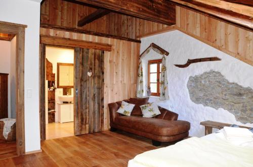 ein Schlafzimmer mit einem Ledersessel und einer Couch in der Unterkunft Wohlfühloase Koglerhof in Friesach