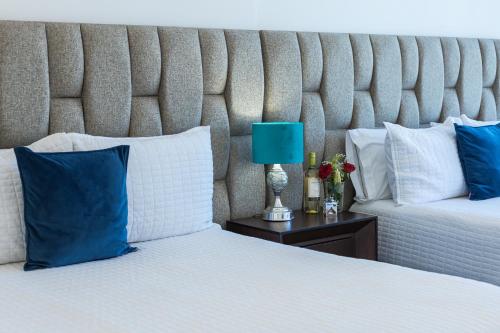 a bedroom with two beds with blue and white pillows at Aria Ocean Condominios in Nuevo Vallarta 