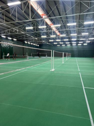 a tennis court with people playing tennis on it at The Orchard Cebu Hotel & Suites powered by Cocotel in Cebu City