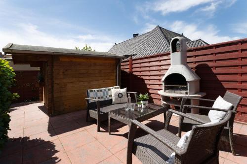 a patio with a grill and a table and chairs at Ostseestern in Grömitz