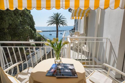 a vase of flowers on a table on a balcony at Hotel Helvetia in Sestri Levante
