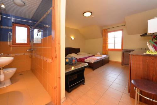 a bathroom with a toilet a sink and a bed at Karkle Beach Apartments in Karklė