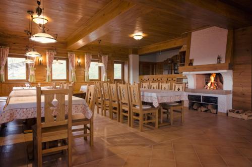a dining room with a fireplace and a table and chairs at Samedru in Măgura