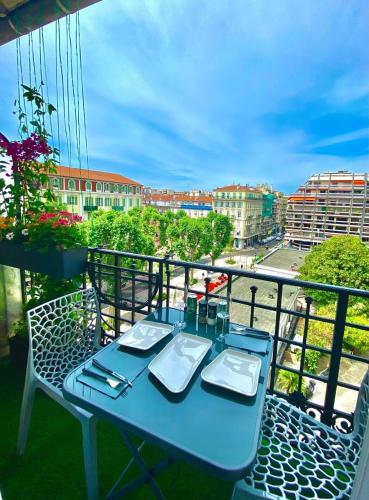 une table bleue sur un balcon avec vue sur la ville dans l'établissement Petit Bijou niçois, à Nice
