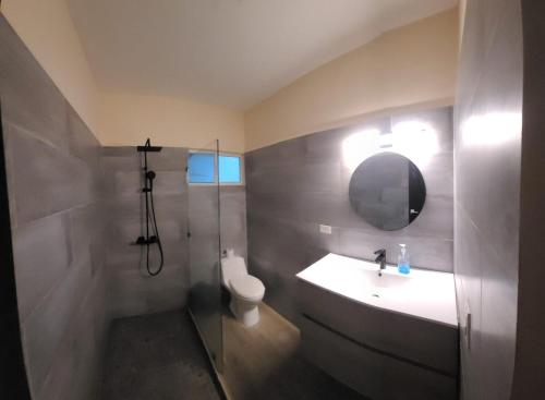 a bathroom with a sink and a toilet and a mirror at Casa Bella Vista in Bluefields