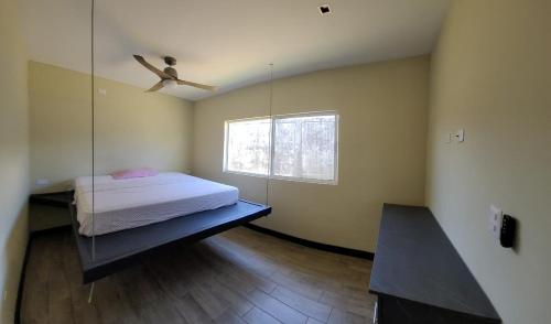 a bedroom with a bed and a ceiling fan at Casa Bella Vista in Bluefields