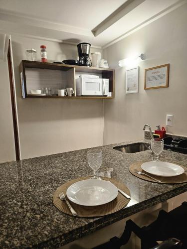 a kitchen with a counter with two plates and a sink at FLAT BLUE SUNSET in João Pessoa