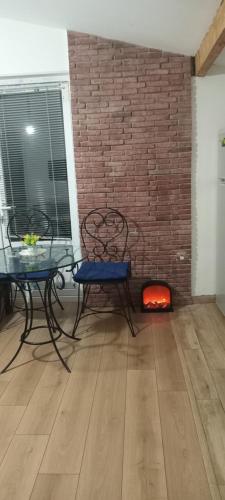 a room with a table and chairs and a brick wall at Ksenia's apartment in Borjomi