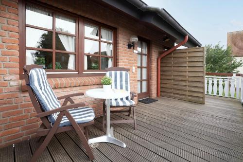 2 Stühle und ein Tisch auf einer Terrasse in der Unterkunft Ostseegarten Goldulme in Kellenhusen