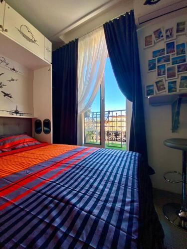 une chambre avec un lit et une grande fenêtre dans l'établissement Petit Bijou niçois, à Nice