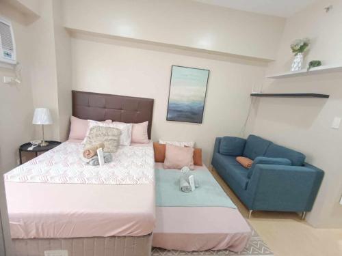 a bedroom with a bed and a blue couch at Cebu Stay Rental - Sunvida Tower Residences in Cebu City