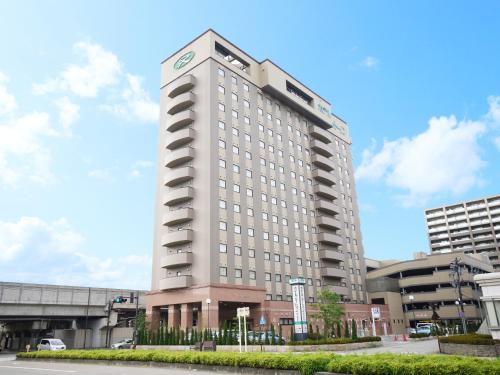 a tall white building with a lot of windows at Hotel Route-Inn Kanazawa Ekimae in Kanazawa
