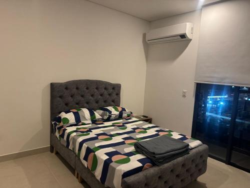 a bedroom with a bed with a quilt on it at Espectacular Apartamento en Santa Marta in Playa Bello Horizonte