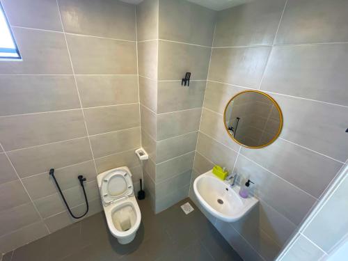 a bathroom with a toilet and a sink and a mirror at Mutiara Melaka Beach Resort SeaView in Kampong Bukit Darat