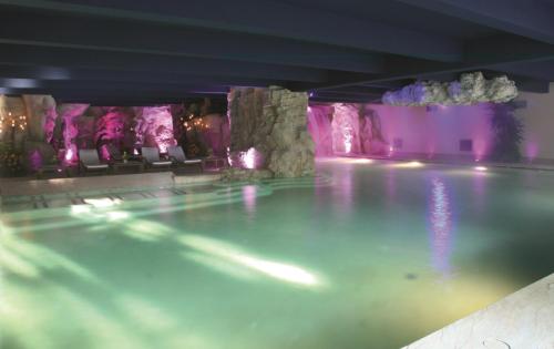 a swimming pool with a water feature in a building at Hotel Regina Palace in Stresa