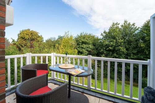 ein Tisch und zwei Stühle auf einem Balkon in der Unterkunft Muschelbank in Scharbeutz