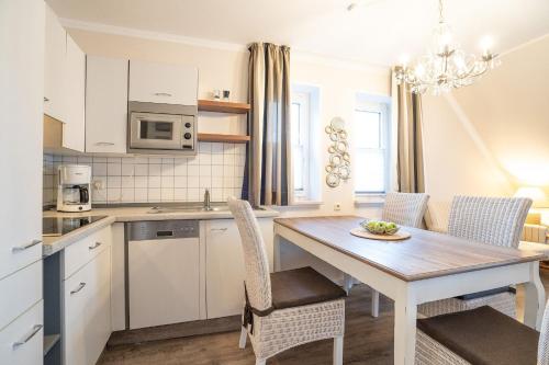 eine Küche und ein Esszimmer mit Tisch und Stühlen in der Unterkunft Muschelbank in Scharbeutz