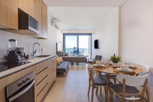 a kitchen and living room with a table and a dining room at Aria Ocean Condominios in Nuevo Vallarta 