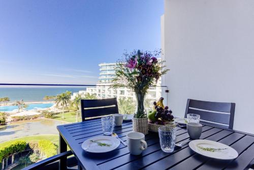 a blue table with a vase of flowers on it at Aria Ocean Condominios in Nuevo Vallarta 
