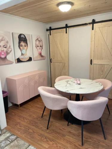 a table and chairs in a room with pictures on the wall at Chic Centrally Located 2BR Townhome at the Rez Sleeps 6 in Brandon