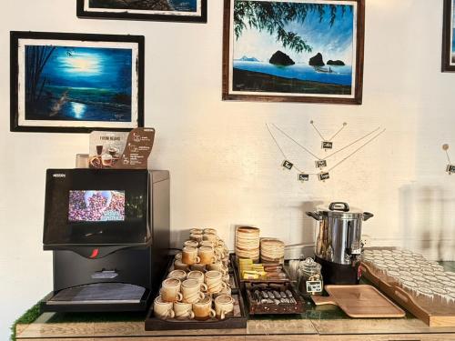 een aanrecht met een koffiezetapparaat en zoete deegwaren bij Arawan Beach Resort Krabi in Ao Nam Mao
