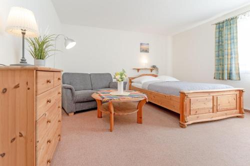 沙博伊茨Fahrenkrug Westbrise的一间卧室，里面有一张床、一张沙发和一张桌子