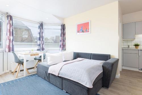 Un dormitorio con una cama y un escritorio y una cocina. en Haus Panorama Laboe Wohnung 5, en Laboe