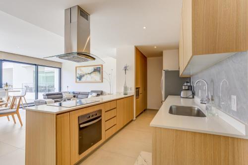 a kitchen with a sink and a stove top oven at Aria Ocean Condominios in Nuevo Vallarta 