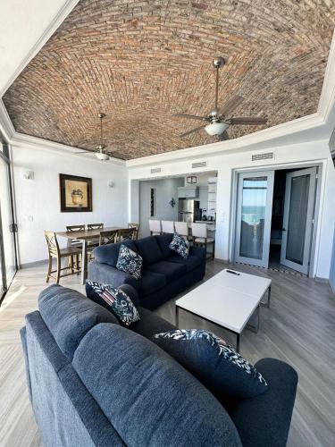 a living room with a blue couch and a table at Palacio Del Mar - Oceanfront in Puerto Peñasco