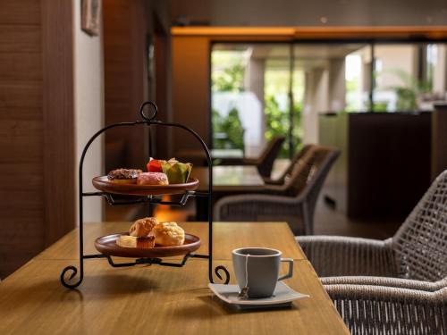 a table with two plates of pastries and a cup of coffee at Glamday Style Okinawa Yomitan Hotel & Resort in Yomitan