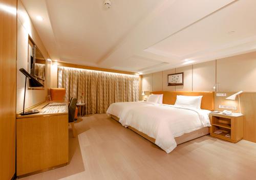 a large bedroom with a large bed and a television at Royal Dragon Hotel in Macau