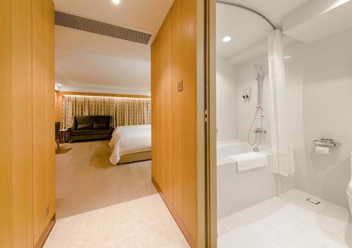 a bathroom with a shower and a bed and a tub at Royal Dragon Hotel in Macau