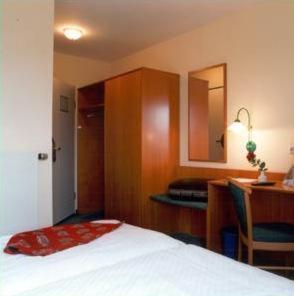 um quarto de hotel com uma cama e uma secretária em ARC Hotel em Dieskau