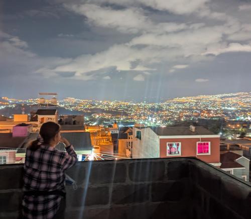 a woman standing on top of a building looking at a city at Hermoso Apartamento de 1 Habitación, Residencial Lomas del Dorado in Tegucigalpa