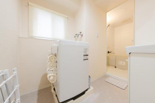 a white refrigerator in a kitchen with a window at シマエナガ札幌 in Sapporo