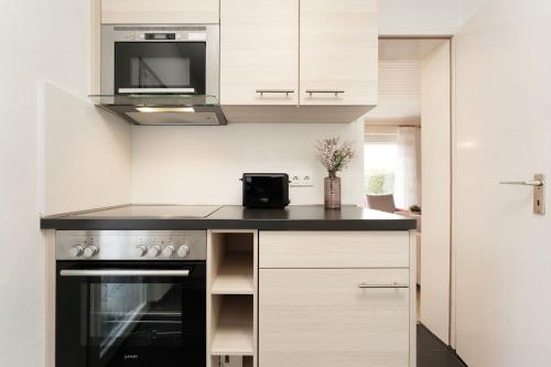 a kitchen with white cabinets and a black stove top oven at Ferienhaus Schneider- Snieder&#039s Hoeg in Lenste