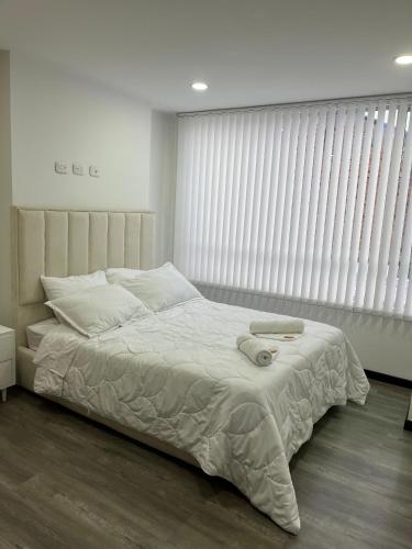 a bedroom with a bed and a window with blinds at hermoso apartamento central, capacidad 6 personas in Pasto