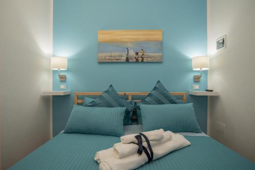 a blue bedroom with a bed with towels on it at Bed & breakfast Giulio in Noto