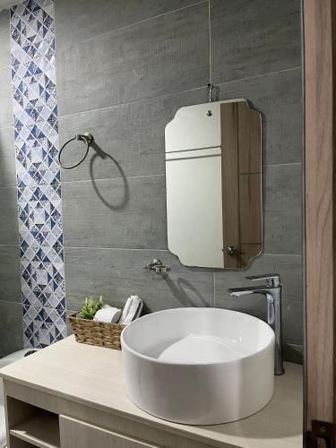 a bathroom with a white sink and a mirror at Hermoso apartamento, capacidad 8 personas in Pasto