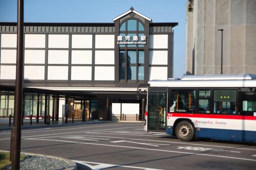 a bus is parked in front of a building at Minkago 鹿児島駅前 #KG1 in Kagoshima